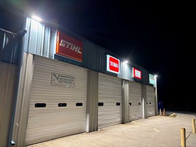 Commercial storefront with illuminated brand signage and exterior lighting at night