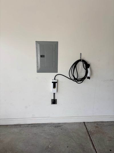 Level 2 EV charger installation in residential garage with NEMA 14-50 outlet and dedicated breaker