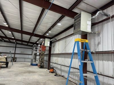 Commercial warehouse electric unit heater installation with overhead conduit run